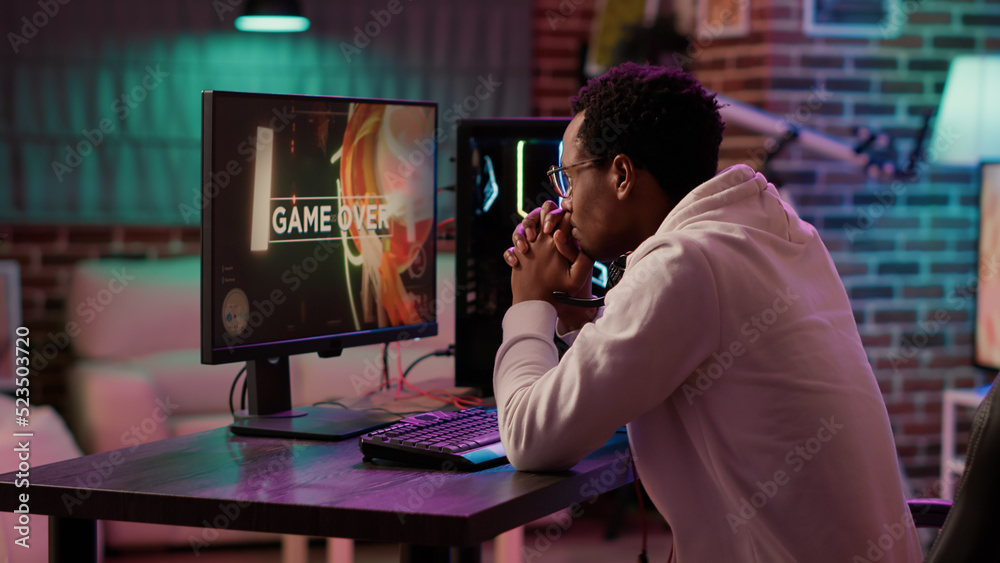 Handheld shot of gamer streaming multiplayer first person shooter angry  after losing online tournament on gaming pc. African american man playing  internet action game upset after failing level. Photos | Adobe Stock