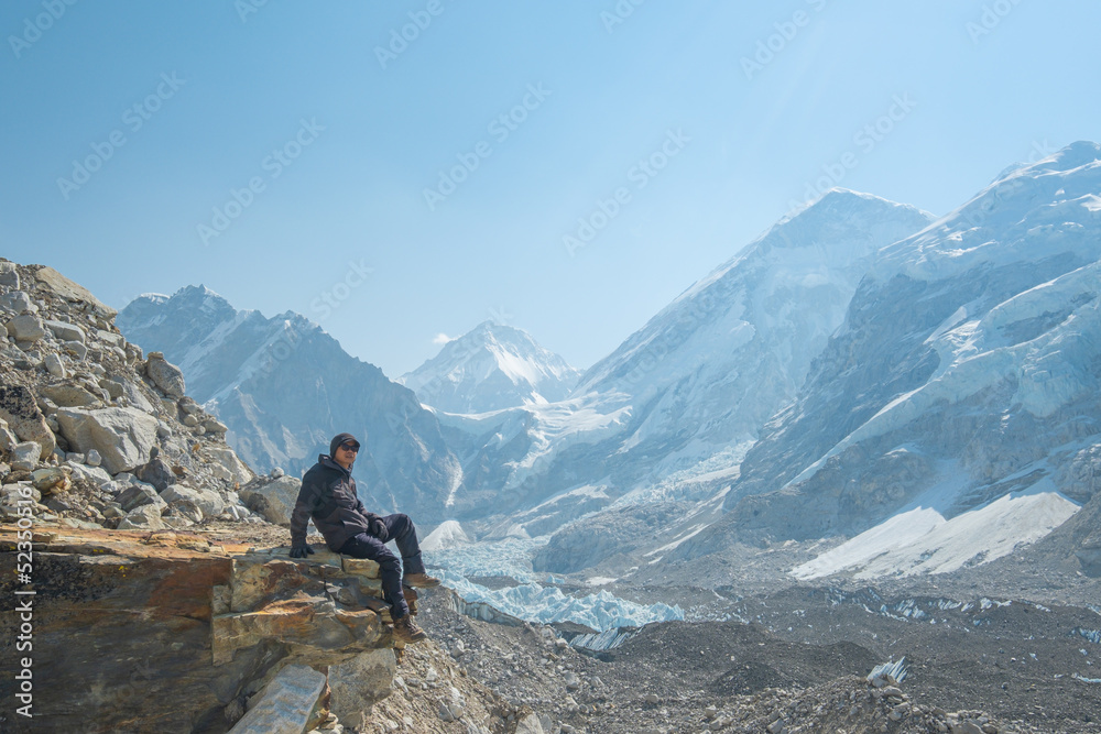 Male backpacker enjoying the view on mountain walk in Himalayas. Everest Base Camp trail route, Nepal trekking, Himalaya tourism.