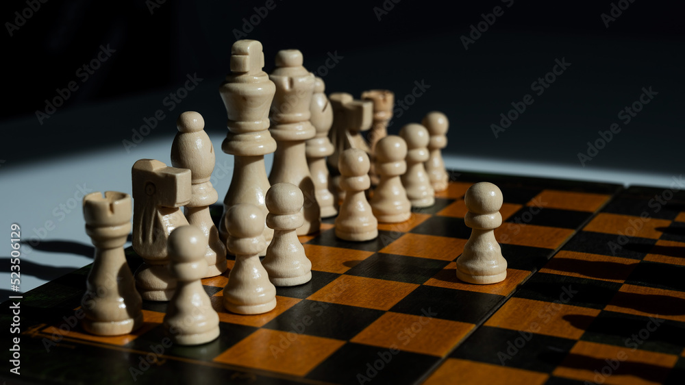 Chessboard with pieces on a white table. Chessboard with pieces on a white table.