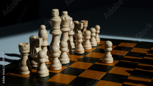 Chessboard with pieces on a white table. 