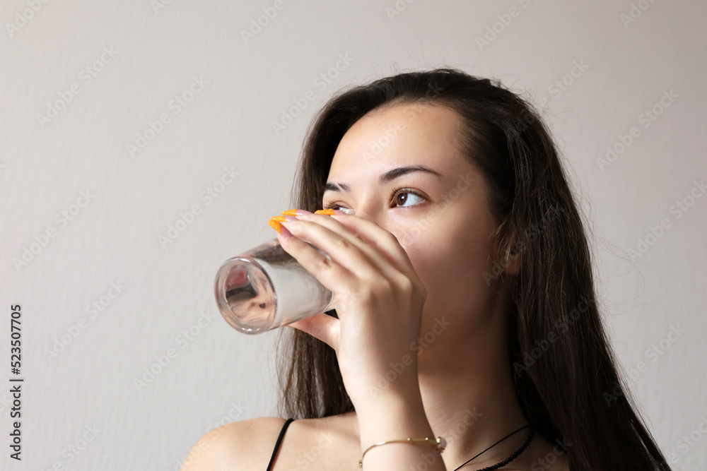 Pretty young girl drinking clean water, glass in female hand close up. Concept of thirst, diet, mineral drink, skin care Pretty young girl drinking clean water, glass in female hand close up. Concept of thirst, diet, mineral drink, skin care