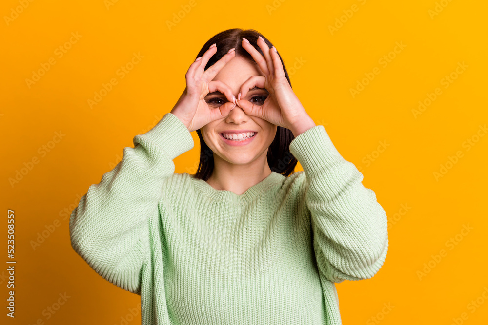 Photo of young pretty woman show fingers binoculars glasses symbol isolated over yellow color background Photo of young pretty woman show fingers binoculars glasses symbol isolated over yellow color background