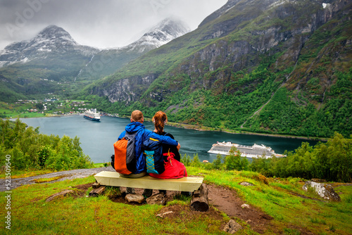 Couple of hikers looking on cruise ship in Norway