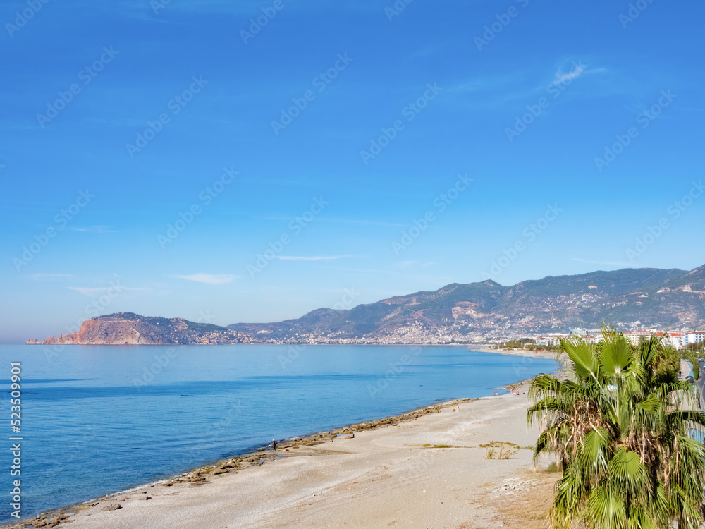 The Alanya Peninsula with fortress and old city, view from the beach with calm sea
