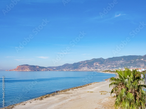 The Alanya Peninsula with fortress and old city  view from the beach with calm sea