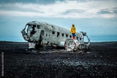 Woman in yellow jacket on Solheimasandur Plane Wreck in Iceland photo