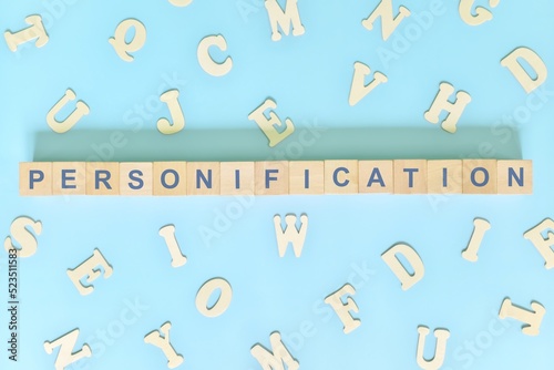Personification figure of speech concept in English grammar class lesson. Wooden blocks typography flat lay in blue background.	
