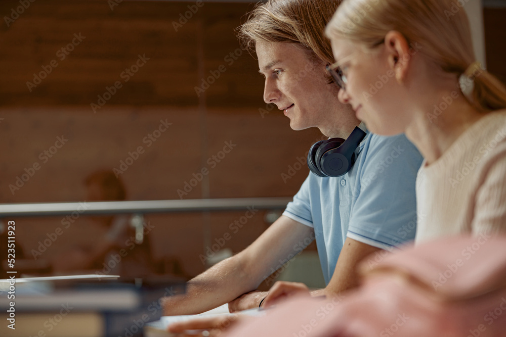 Students sit in the library and take notes while preparing for the exam Students sit in the library and take notes while preparing for the exam