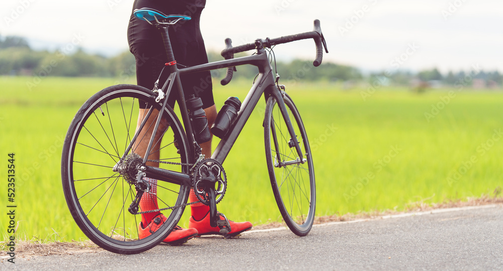 Rear view of a cyclist on the road in the evening. Fitness concept. Rear view of a cyclist on the road in the evening. Fitness concept.