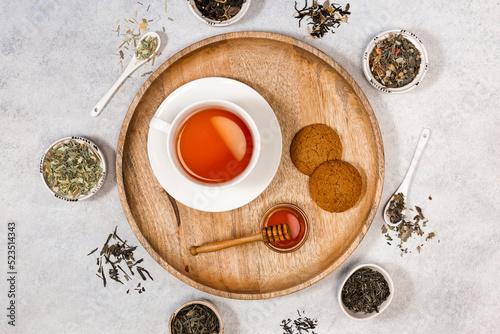 A cup of tea and coockies and honey on a wooden tray. Various types of tea. View from above.