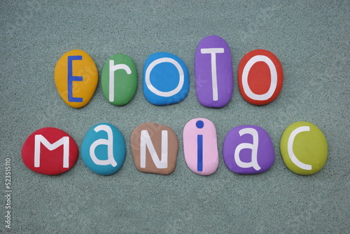 Erotomaniac, one affected with erotomania, creative text composed with multi colored stone letters over green sand