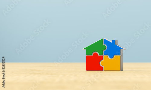 Multicolored puzzle house on a wooden surface. 3d render illustration.
