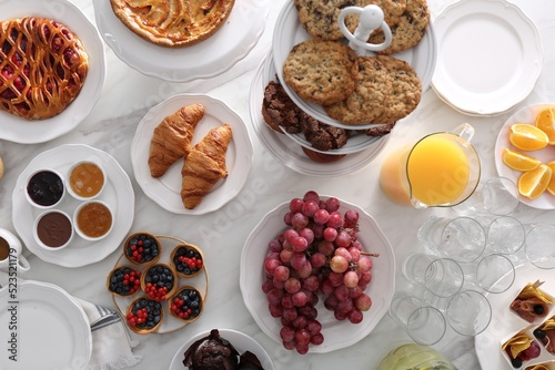 Variety of snacks on white marble table in buffet style, flat lay