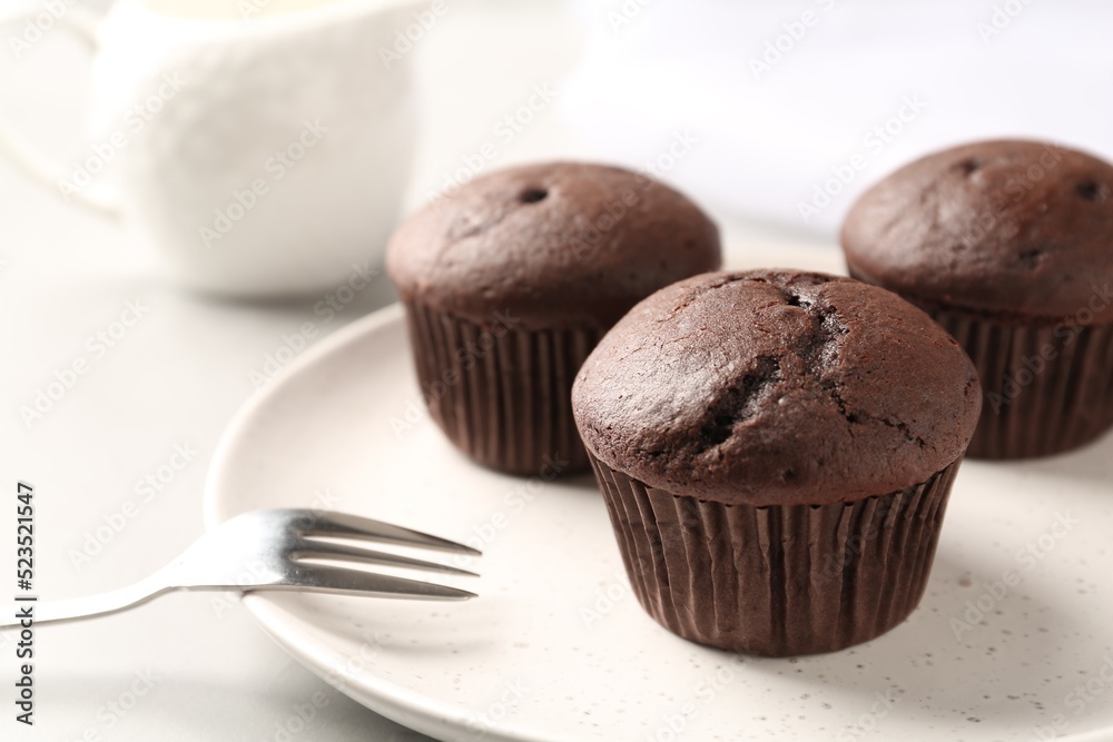 Delicious chocolate cupcakes on white table, closeup Delicious chocolate cupcakes on white table, closeup