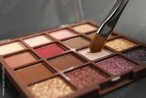 Colorful eyeshadow palette with brush, closeup view