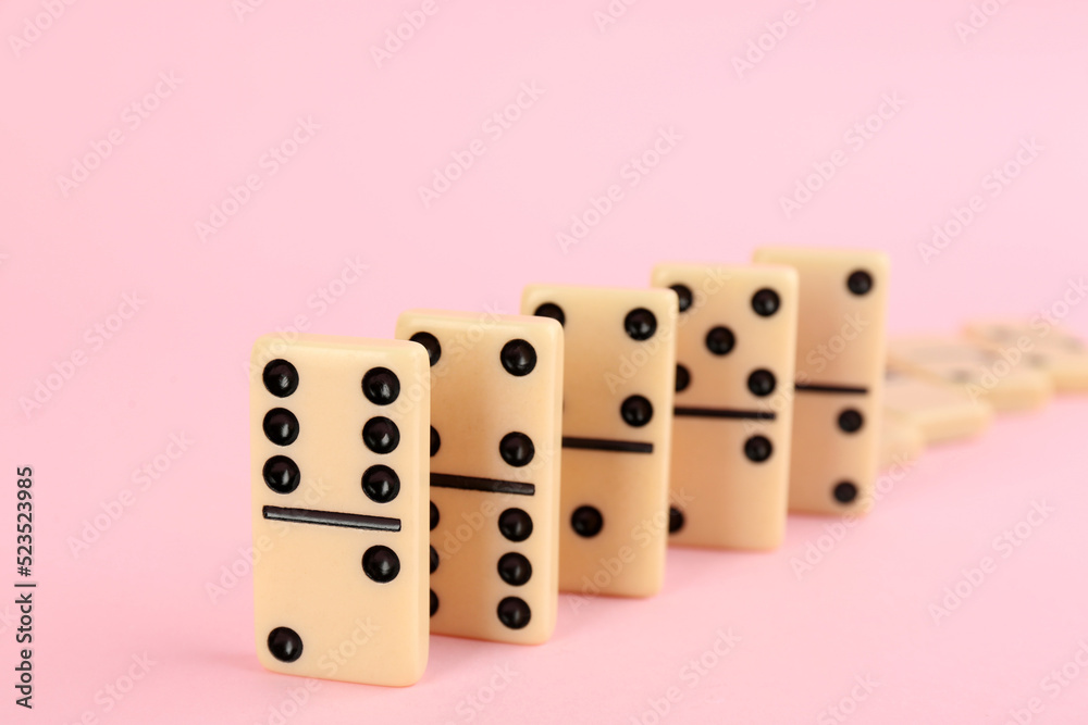 White domino tiles falling on pink background White domino tiles falling on pink background