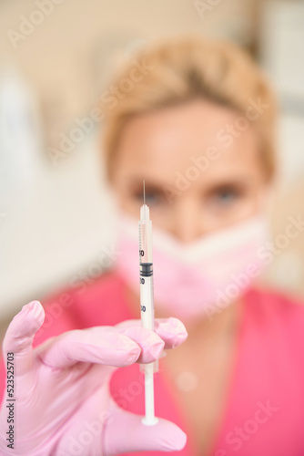 Woman cosmetologist holds in her hand syringe for injection