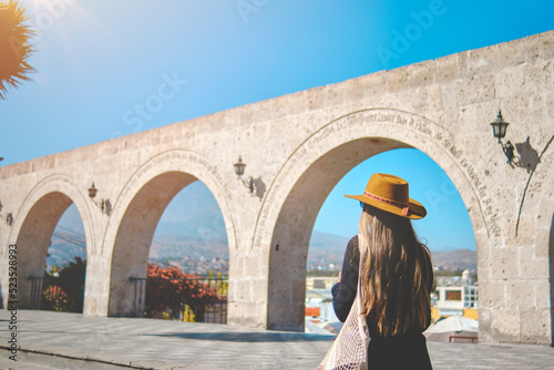 Beautiful smiling woman enjoying on vacation in Yamahuara viewpoint, Arequipa, Peru. Selective Focus. Square of Yanahuara. photo