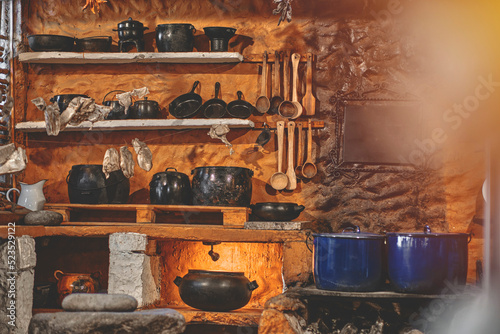 Cast iron pot with fresh herbs, spices and kitchen utensils for tasty cooking on rustic table. Homemade cooking. Dark. photo