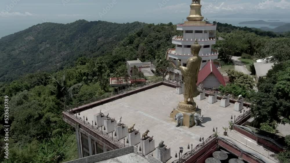 Drone film of buddha statue and temple at  koh samui island in thailand - drone flies around the large statue - Wat Teepangkorn temple