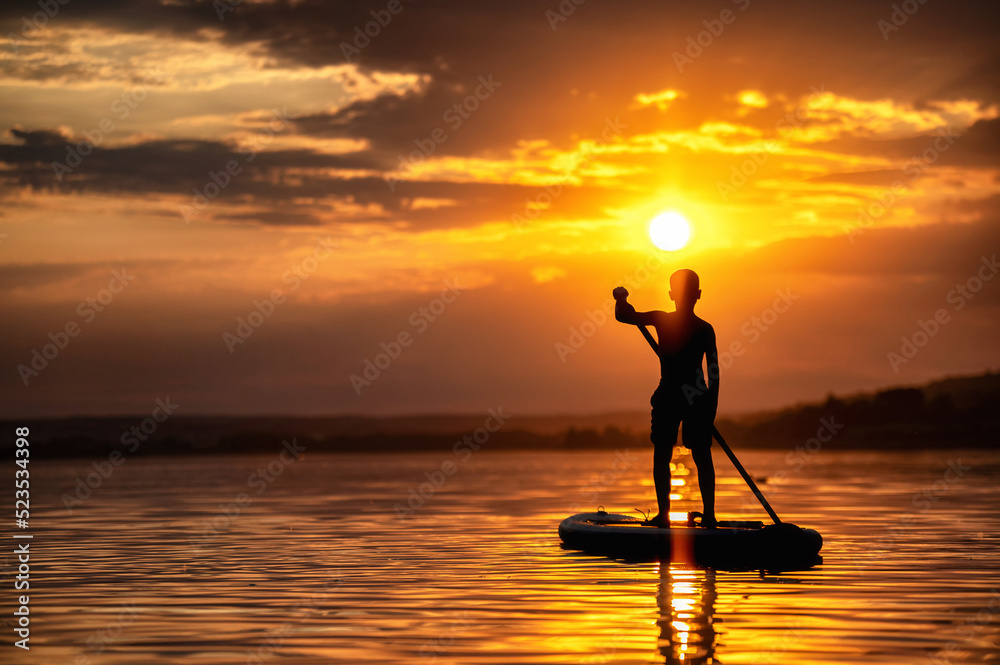 Silhouette eines Menschen auf einem Stand up paddle