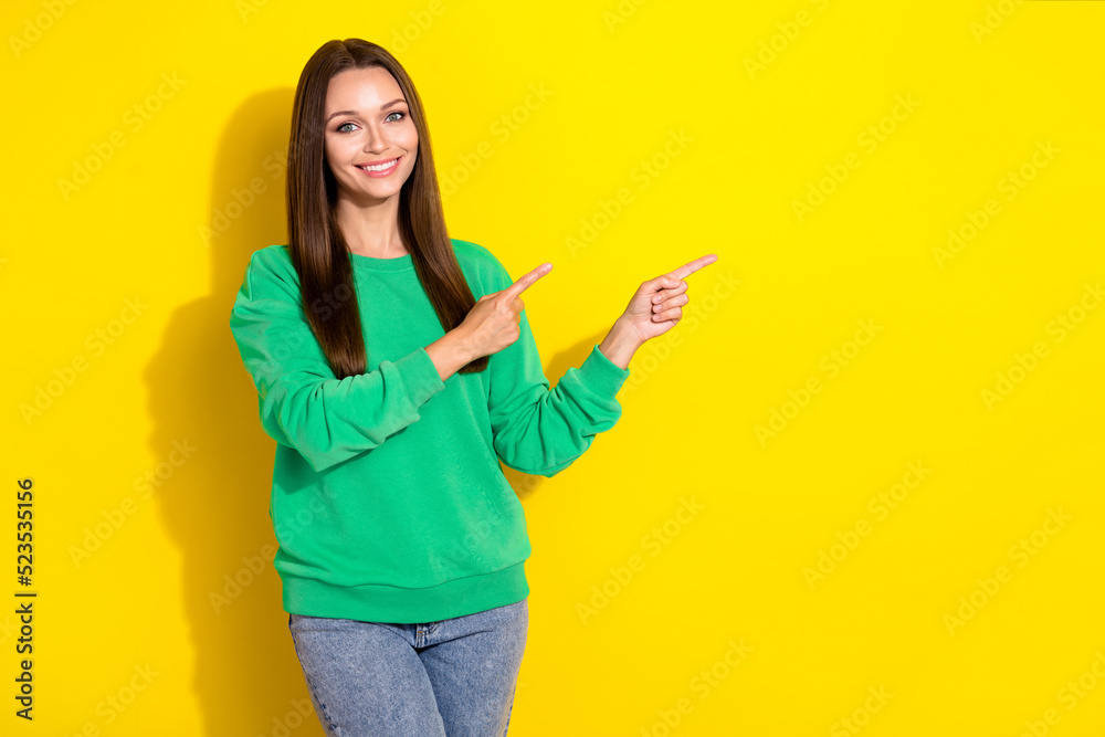 Portrait of young attractive cute pretty woman pointing empty space demonstrating new product her company isolated on yellow color background Portrait of young attractive cute pretty woman pointing empty space demonstrating new product her company isolated on yellow color background