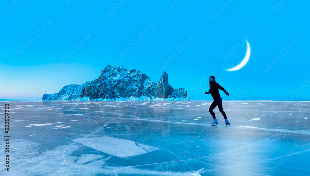 A young happy woman is skating on the transparent ice of the frozen Lake Baikal on a sunny winter day - World-famous figure skater 