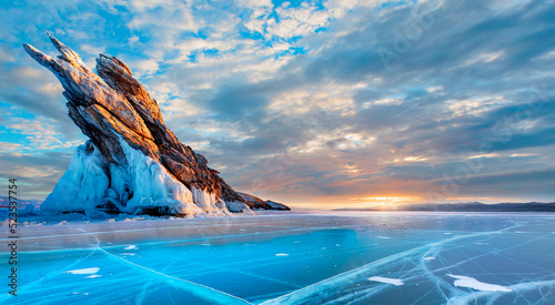 Ogoy island on winter Baikal lake with transparent cracked blue ice at sunrise - Baikal, Siberia, Russia photo