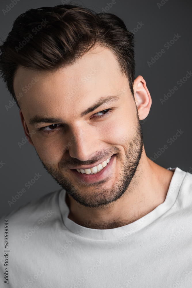 Portrait of cheerful young man looking away isolated on grey. Portrait of cheerful young man looking away isolated on grey.