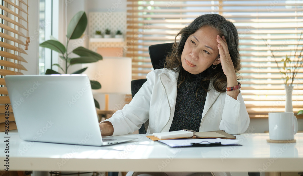 Fototapeta premium Stressed mature senior business woman suffering from headache or migraine.
