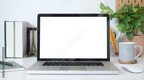 Mock up laptop computer, coffee cup houseplant and stationery on white table. Empty screen for your advertise text.