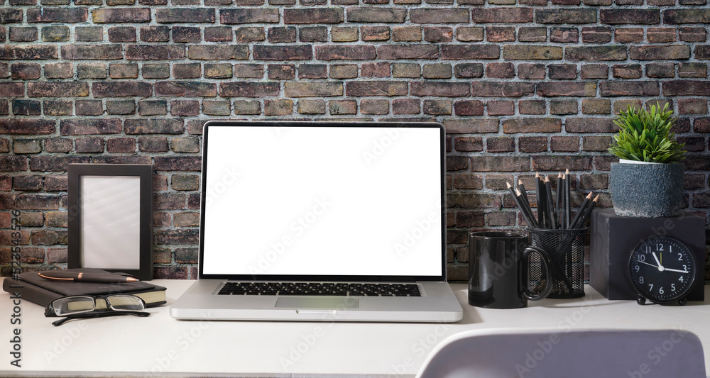 Fototapeta premium Computer laptop with empty screen, coffee cup, potted plant and stationery on white table.