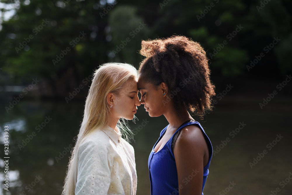 Young women spending time together in nature, near lake, concept of strong, long lasting friendship. Young women spending time together in nature, near lake, concept of strong, long lasting friendship.