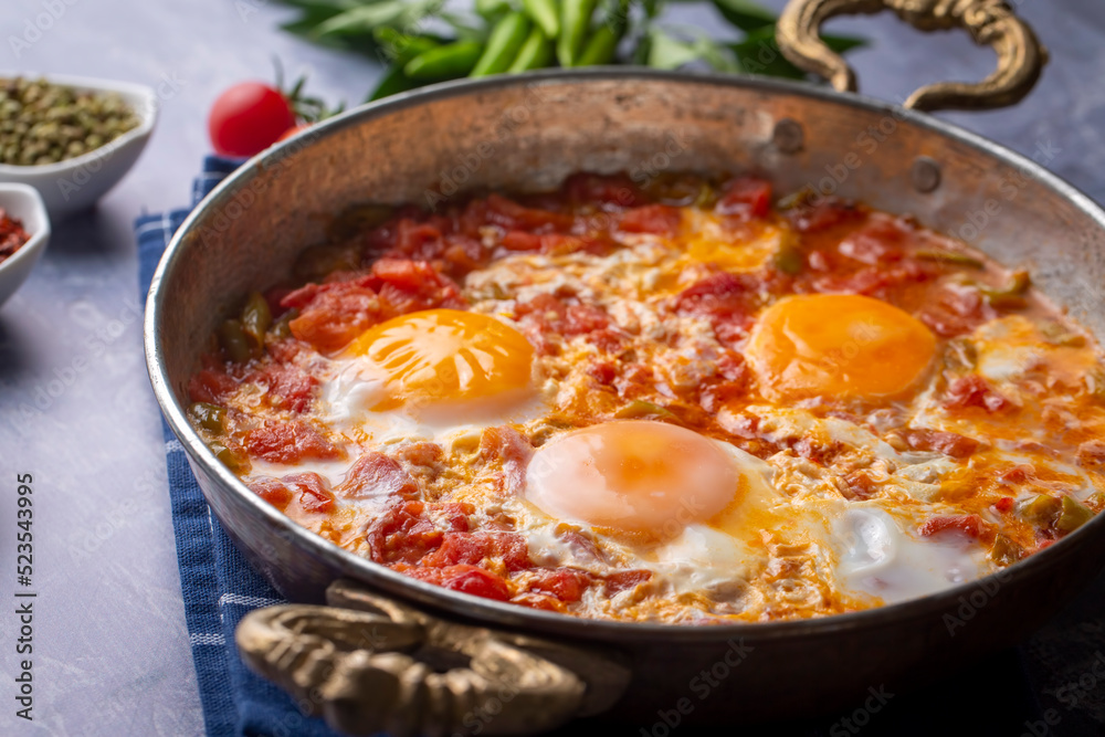 Famous Turkish menemen dinner on table, made by eggs, pepper and tomatoes. Famous Turkish menemen dinner on table, made by eggs, pepper and tomatoes.