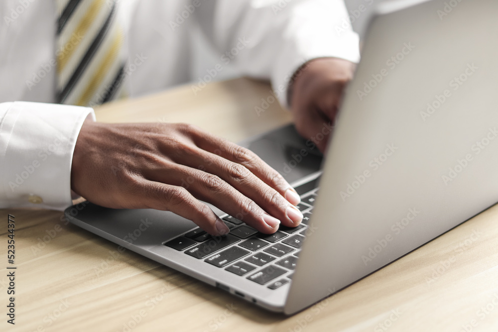 Businessman working with laptop at table in office Businessman working with laptop at table in office
