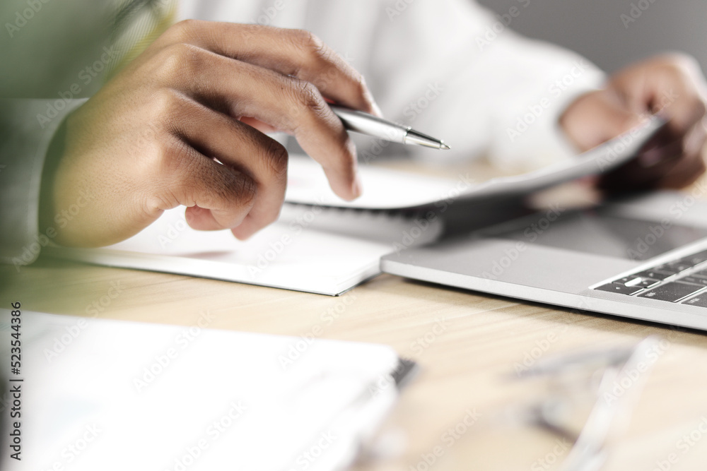 Businessman working on laptop and taking notes Businessman working on laptop and taking notes