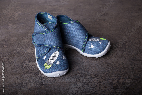 small first shoes for baby toddler, boy, concrete background