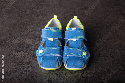baby shoes, small blue sandals on concrete background