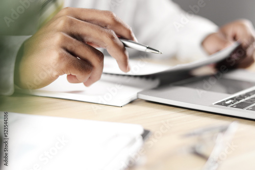Businessman working on laptop and taking notes