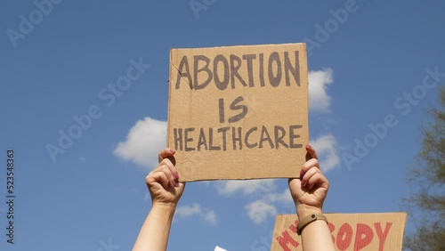 Protester hands holding signs Abortion Is Healthcare, My Body My Choice. People with placards supporting abortion rights at protest rally demonstration. photo