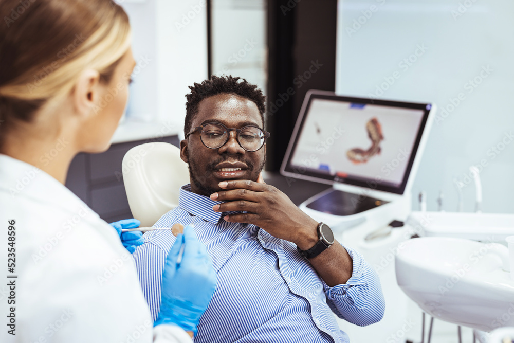Black guy patient with open mouth having dental treatment from female doctor, close up. Man and female doctor while checkup teeth. Healthy lifestyle, healthcare and medicine concept. Black guy patient with open mouth having dental treatment from female doctor, close up. Man and female doctor while checkup teeth. Healthy lifestyle, healthcare and medicine concept.