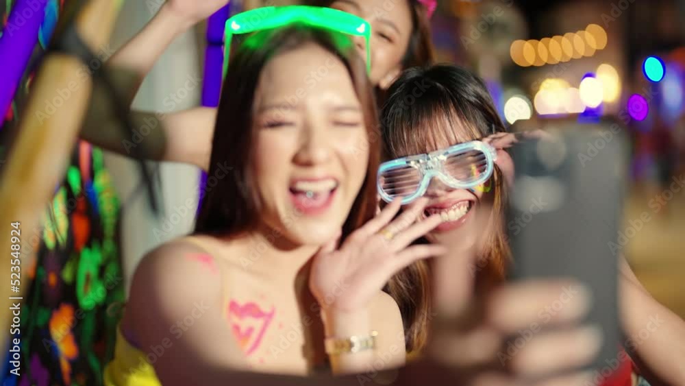 4K Group of Asian woman using mobile phone taking selfie together while celebrating and dancing at full moon beach party event. Female friends enjoy and fun outdoor summer travel vacation in Thailand 4K Group of Asian woman using mobile phone taking selfie together while celebrating and dancing at full moon beach party event. Female friends enjoy and fun outdoor summer travel vacation in Thailand
