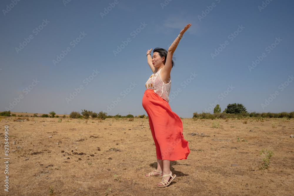 outdoors lifestyle portrait of young happy and beautiful Korean woman enjoying summer holiday while pregnant proud of her belly as mother expecting baby concept outdoors lifestyle portrait of young happy and beautiful Korean woman enjoying summer holiday while pregnant proud of her belly as mother expecting baby concept