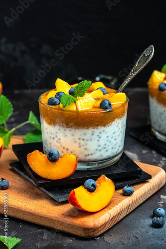 yogurt dessert with peaches blueberry chia on a dark background. Natural detox, fruit dessert, healthy dieting concept