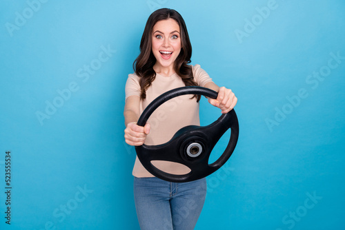 Photo of young ecstatic overjoyed young female use drive simulator train to drive car isolated on blue color background