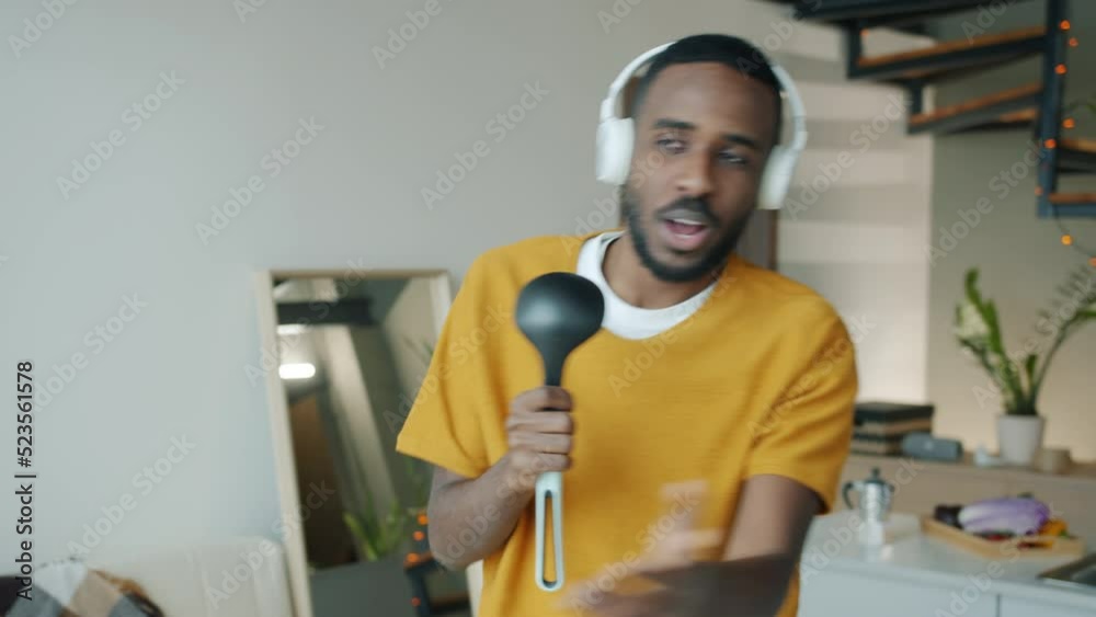 Slow motion of happy African American student relaxxing dancing and singing in kitchen in apartment. Leisure activity and people concept. Slow motion of happy African American student relaxxing dancing and singing in kitchen in apartment. Leisure activity and people concept.