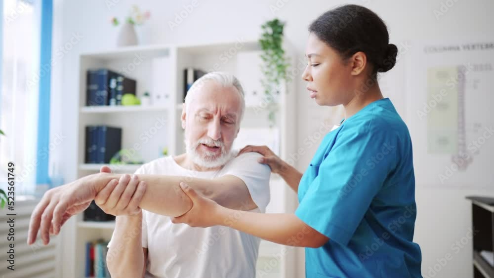 African American doctor examining patient with hand injury, physiotherapy