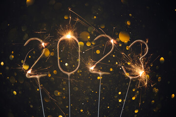 2023 Happy new year Silvester greeting card with burning golden sparklers shiny glitter lights bokeh