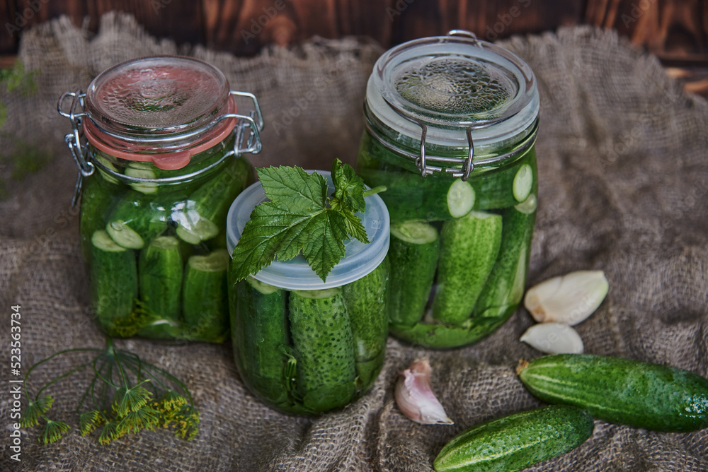 Preservations, conservation. Salted, pickled cucumbers in a jar on an old wooden table. Preservations, conservation. Salted, pickled cucumbers in a jar on an old wooden table.