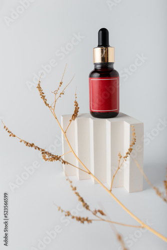 Face skin care cosmetics. Bottle of azelaic or hyalurone acid on white background, decorative concrete elements. Mock up, no brand template photo